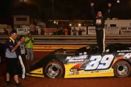 Steve Blackburn climbs atop his car to celebrate his victory. (A&M Photography)